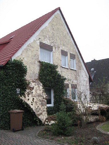 Haus nach Sturmschaden mit abgerissenem Efeu